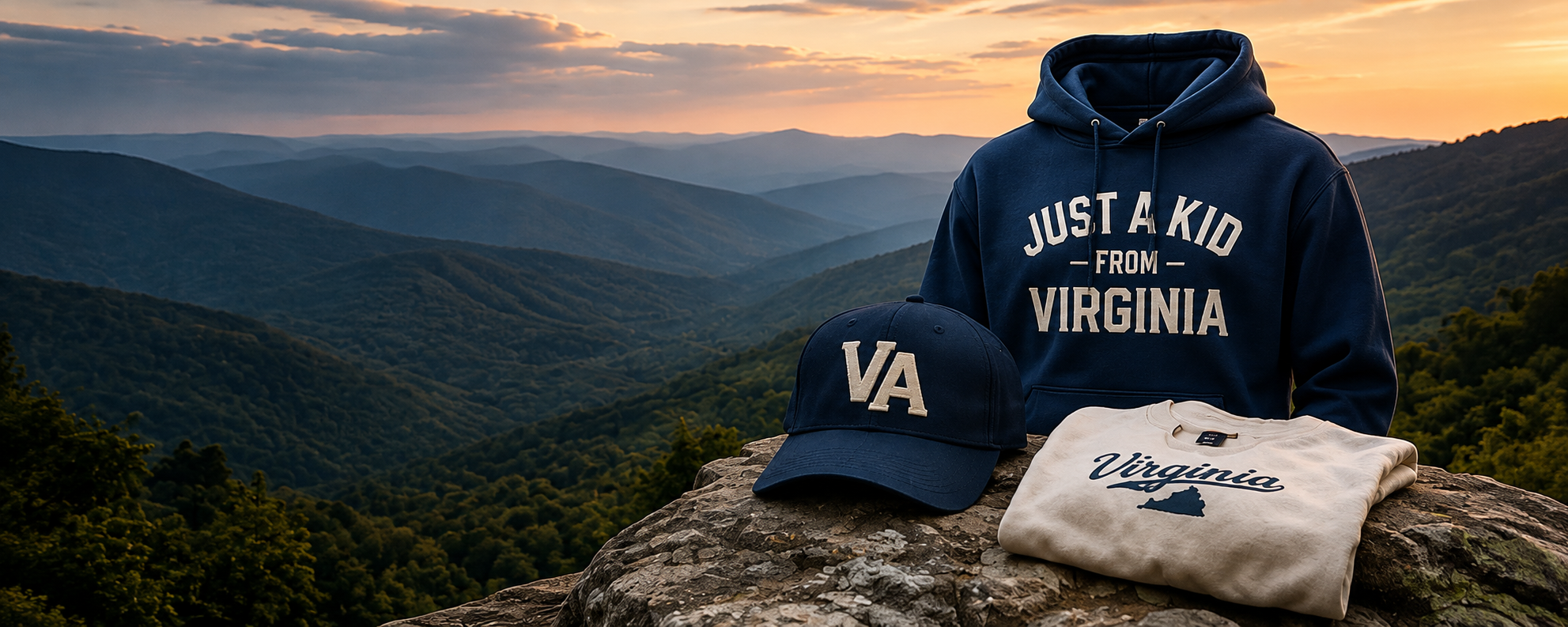 A collection of Virginia-themed apparel and accessories on a rocky surface with a mountain landscape at sunset in the background. Items include a navy hoodie with white text, a navy cap with Virginia abbreviation, and a cream-colored sweatshirt with Virginia and a mountain silhouette.