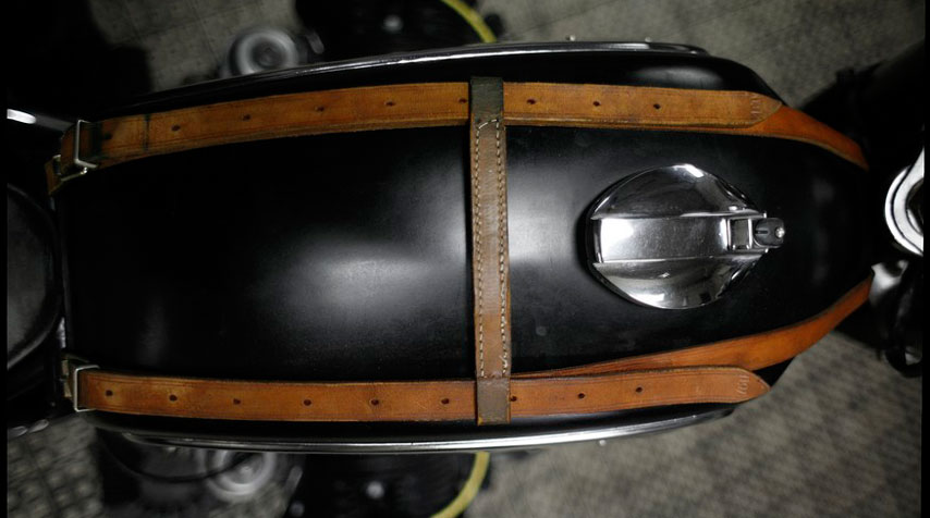 Artisanal tan leather tank straps inspired by equestrian accessories.