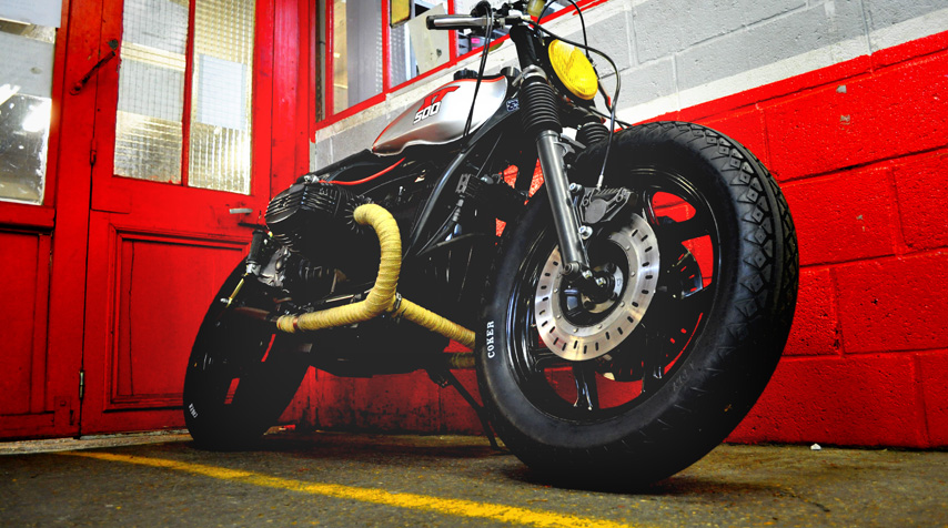 - R100 RS handlebar (shiny black powder coated); - Yamaha R1 front brake master cylinder + clutch lever; - Yellow glass vintage rally car additional light used as the headlight.