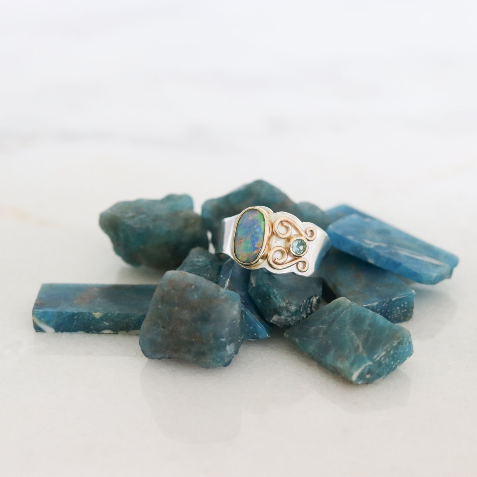 handmade opal ring sitting on apatite stones