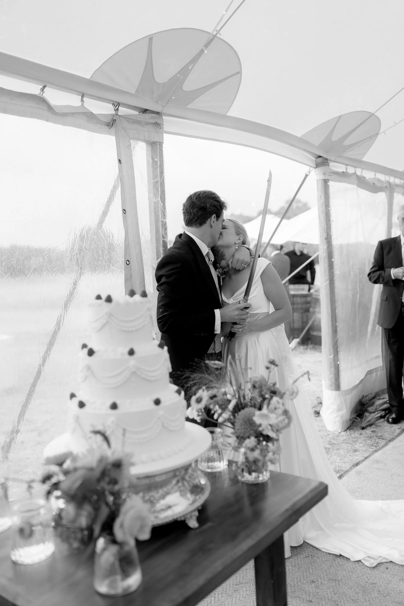 a couple at a hampshire wedding cutting their cake and kissing