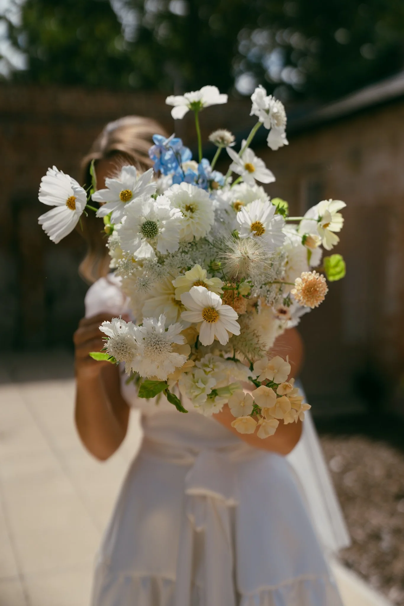 a hampshire bride with a bouquet covering her face