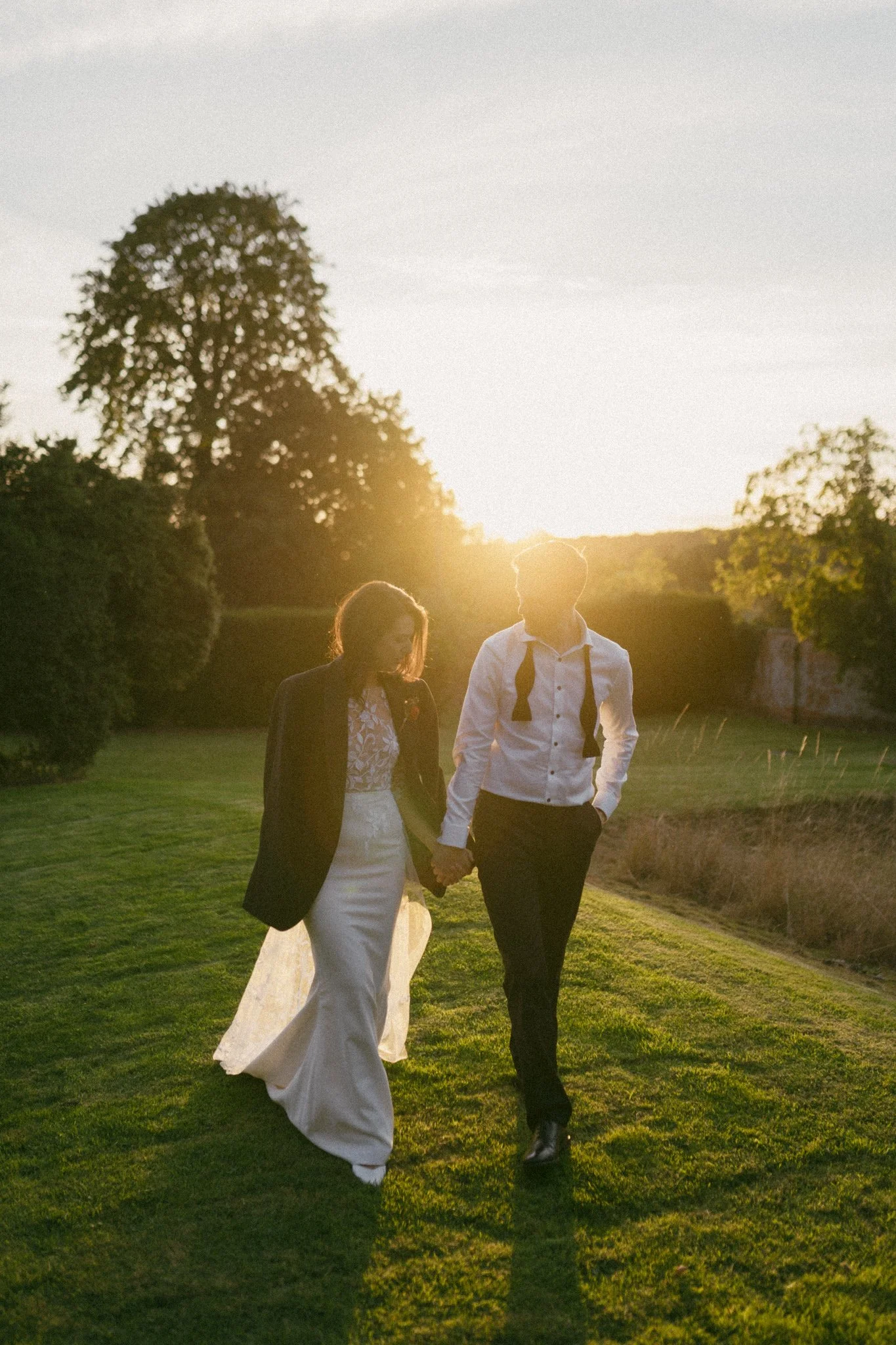 bride and groom walking during sunset