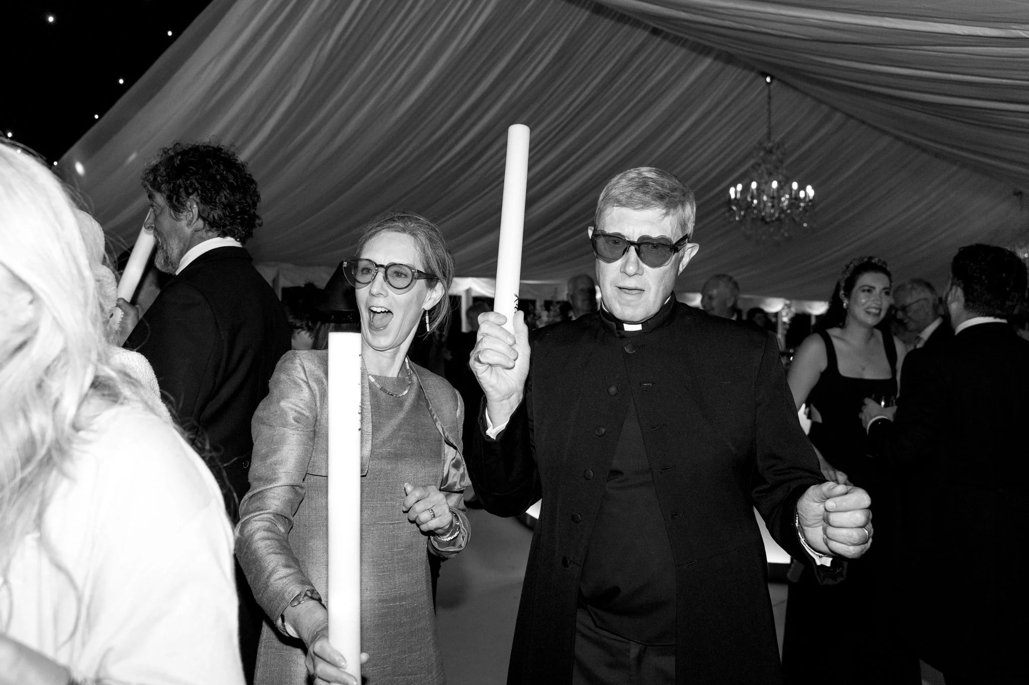 two people with glow sticks at a wedding
