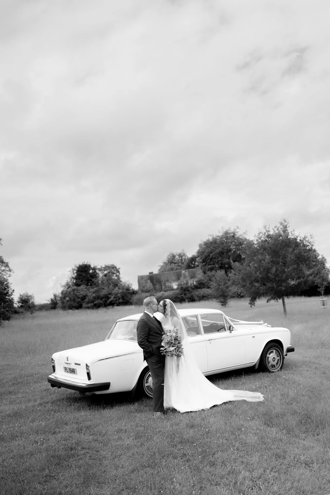 a hampshire wedding with a bride and groom stood in front of a 70s style rolls royce
