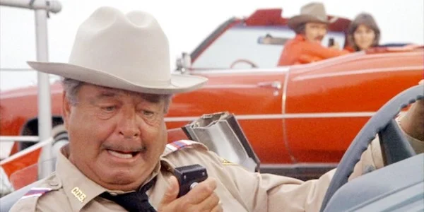 Jackie Gleason (with Burt Reynolds and Sally Field in the background) in Hal Needman’s Smokey and the Bandit