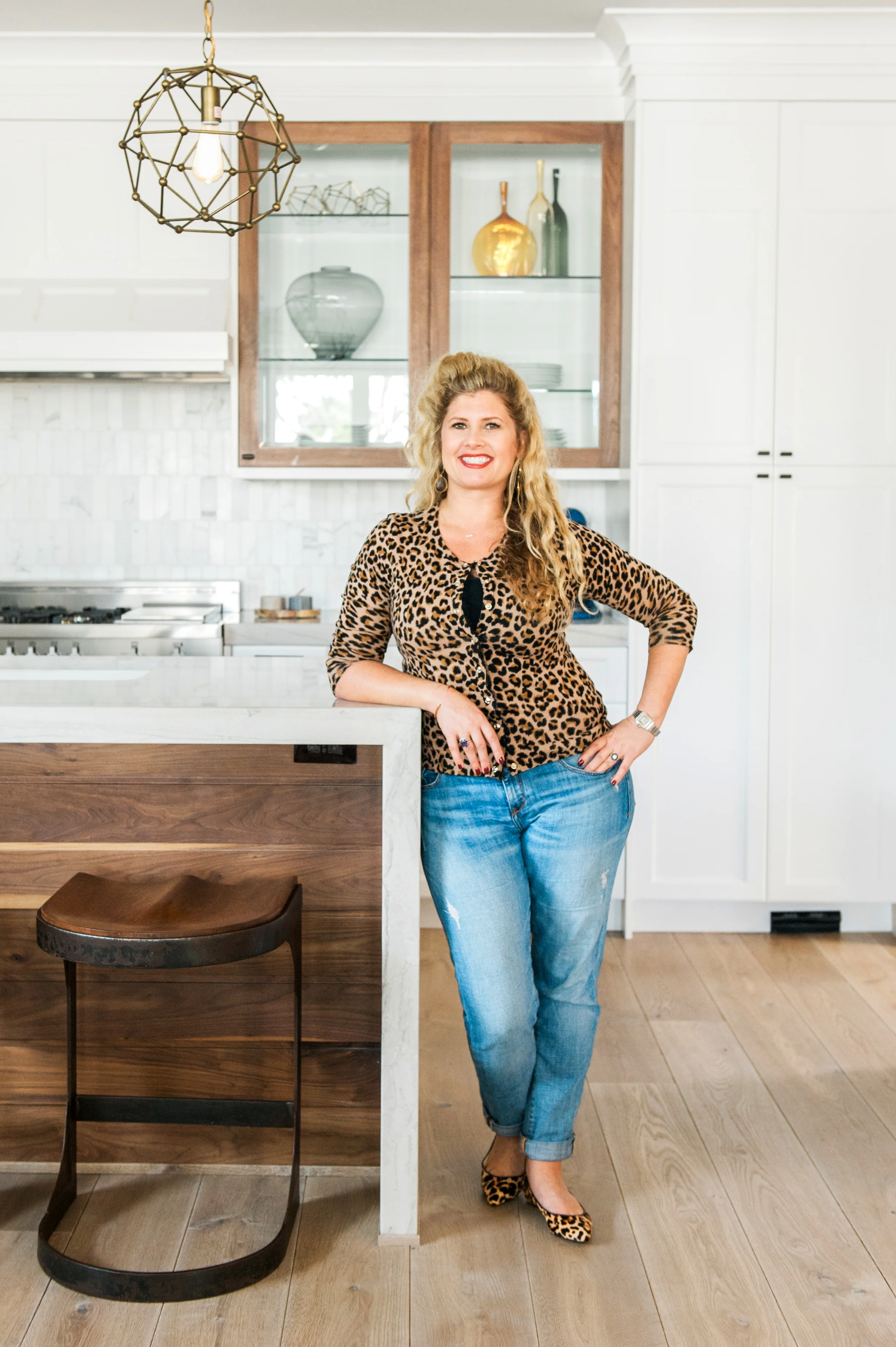 Valerie Saunders, Principal Designer at Sérendipité, poses in her client's newly designed kitchen photography by: Melissa Brandman