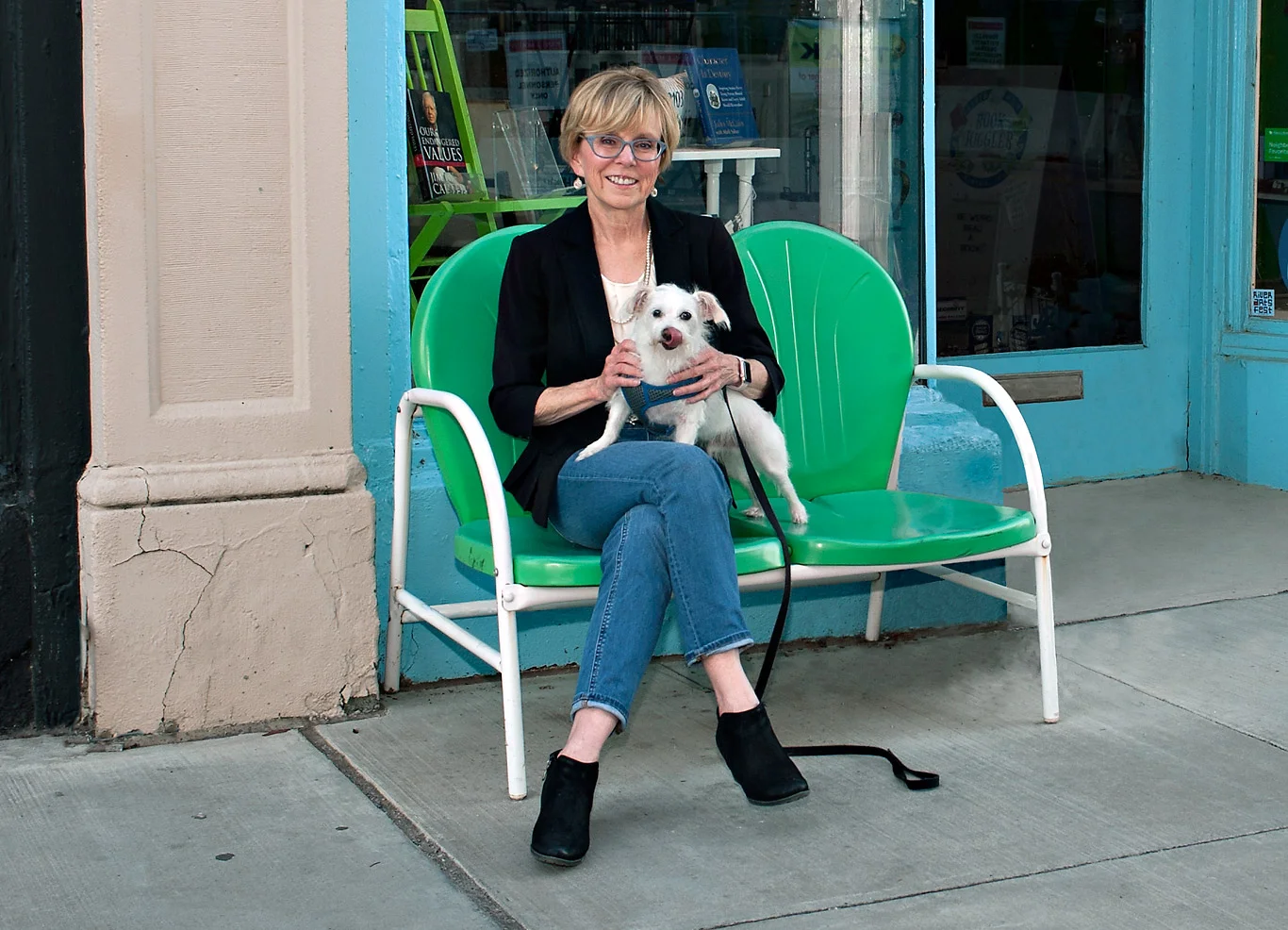 Julia Walker holding dog on bench on sidewalk