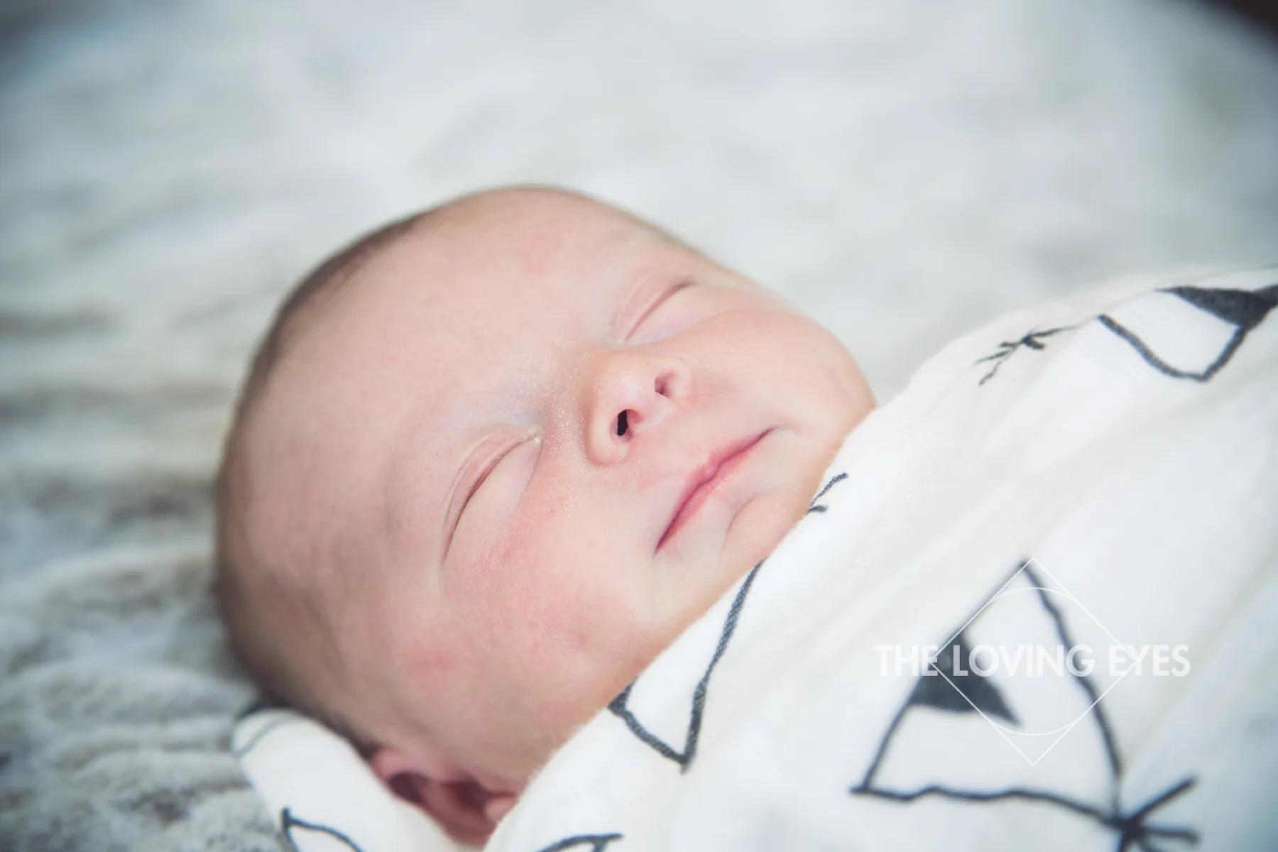 Hawaii newborn photography close-up of swaddled and sleeping baby in home with family