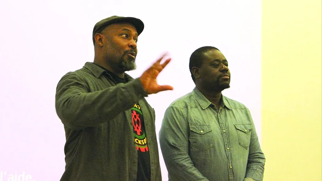 Kali Akuno (left) with Eros Sana, a leading organizer for racial justice, in Paris, France, addressing a gathering during the UN climate change negotiations.