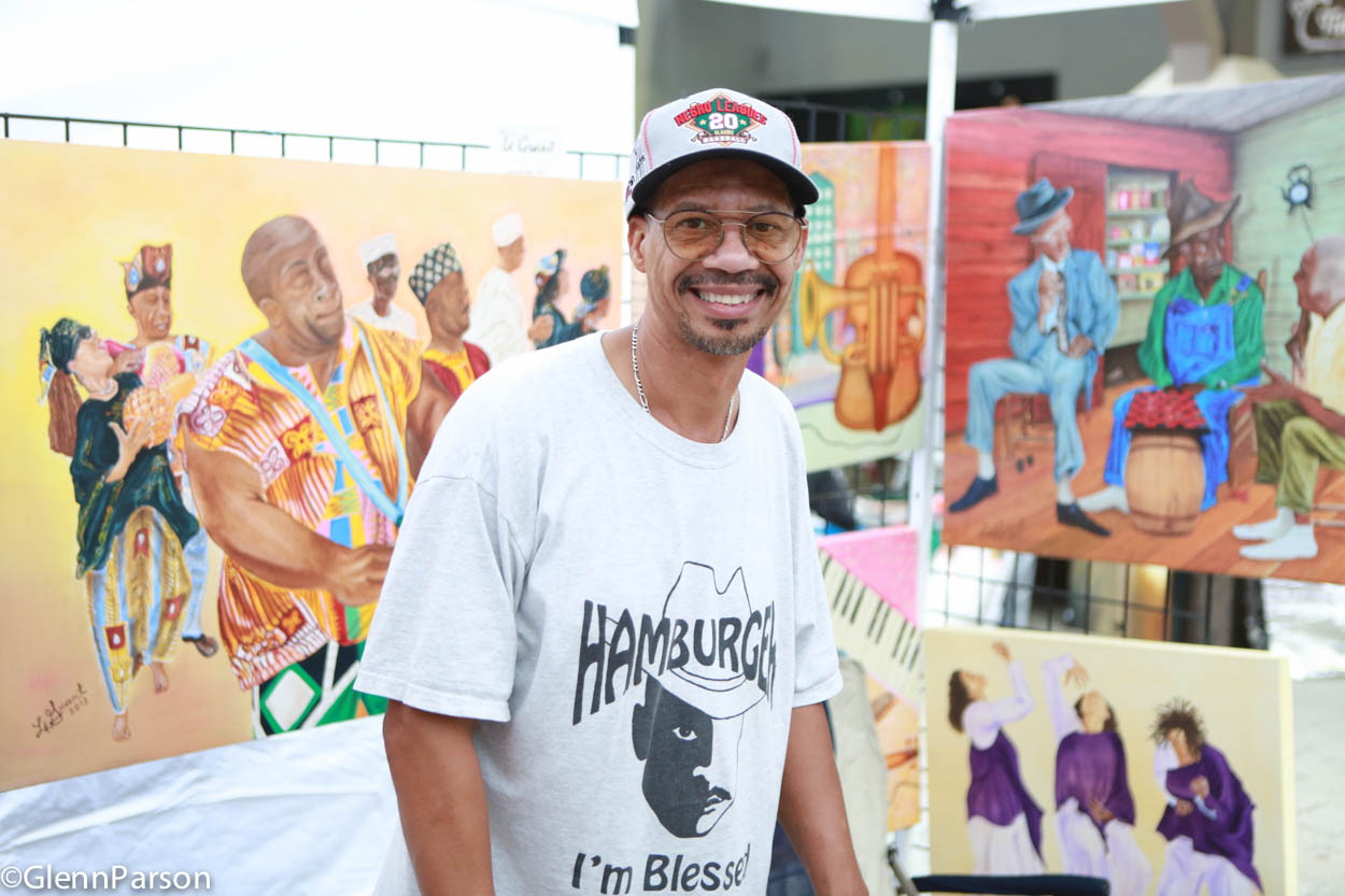 artist LeGrant Taylor in front of his paintings Art Gallery Walk