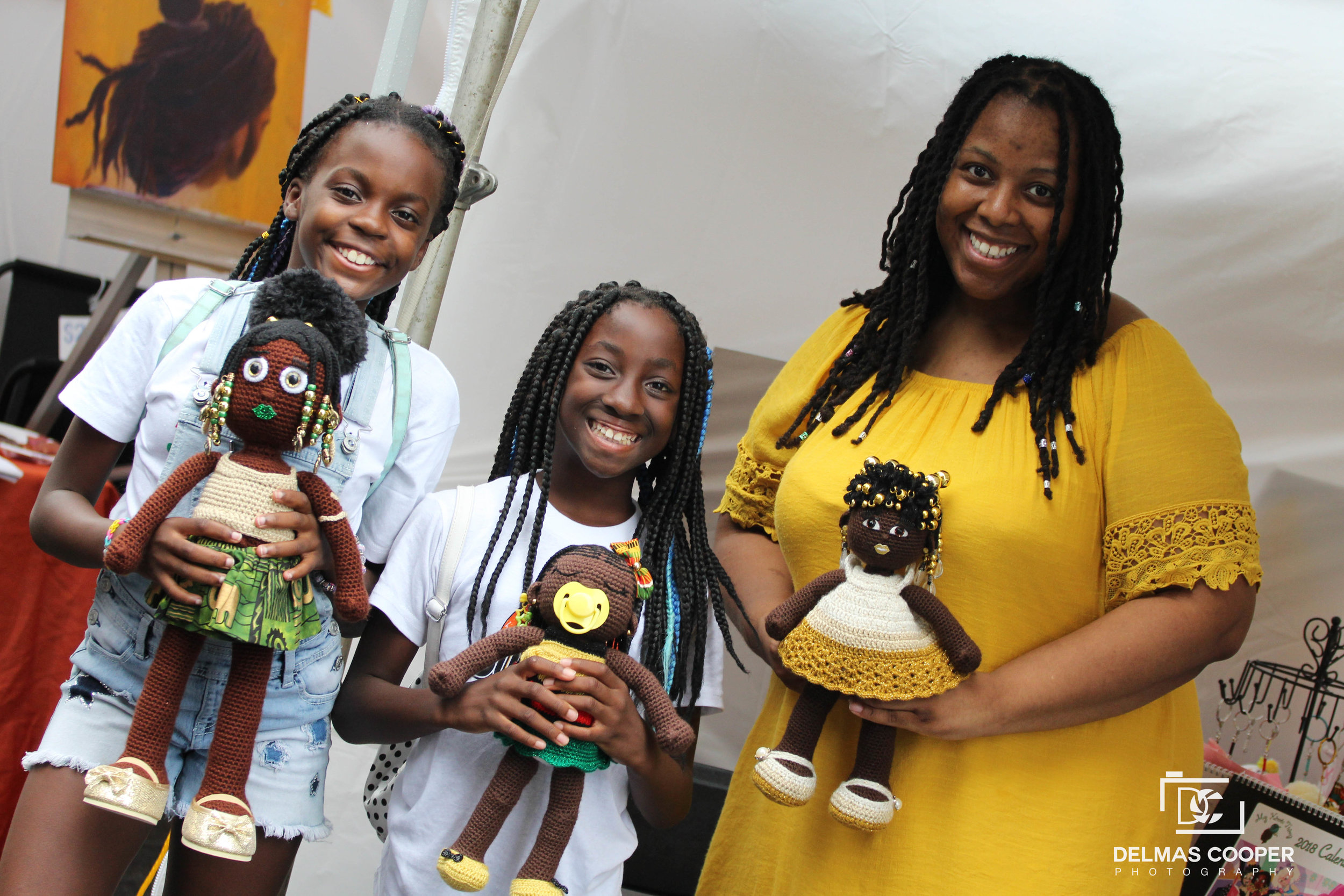 dollmaker Aniqua Wilkerson and two girls holding her handmade dolls