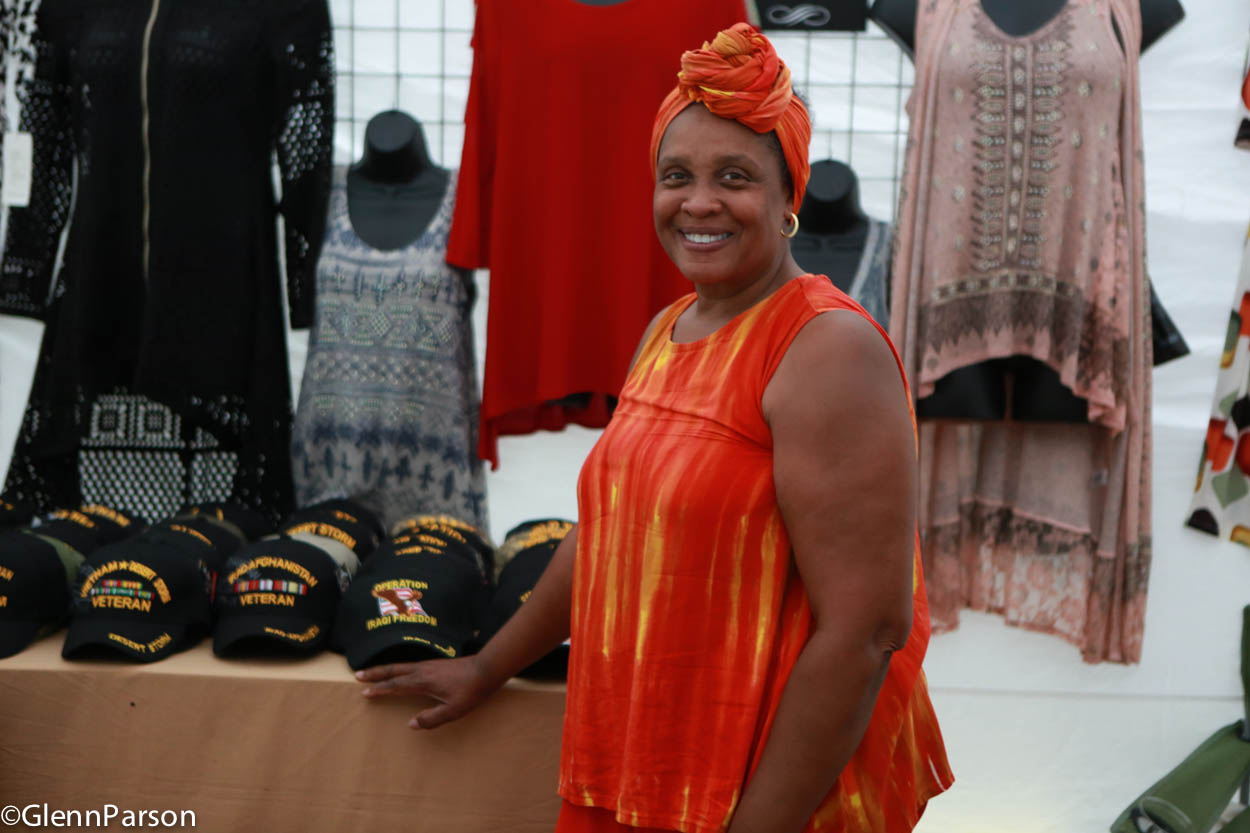 Woman proudly displaying caps in Vendor Marketplace