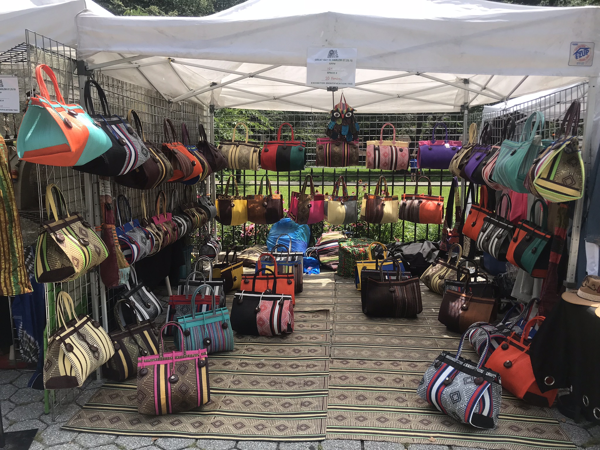recycled handbag artist Adama Sylla's booth showing many colorful bags
