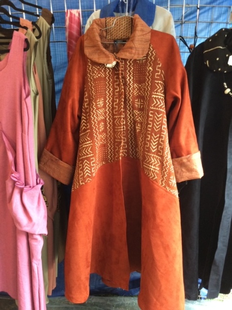 Women's long copper colored coat printed with Adinkra symbols