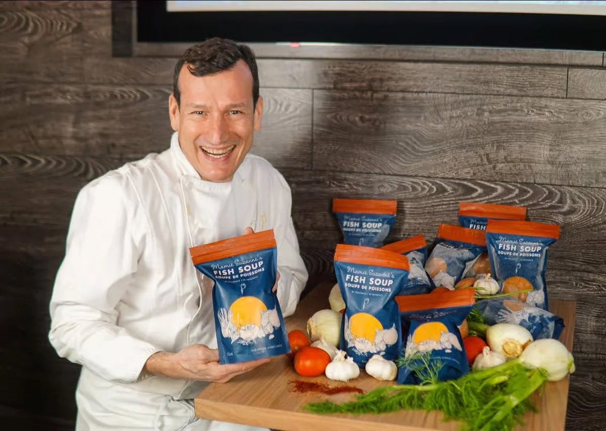 Chef presenting Mamie Suzanne’s Fish Soup packaging designed by Laurelle Armet, featuring bold blue and orange branding inspired by Provence ingredients and traditional French cuisine.