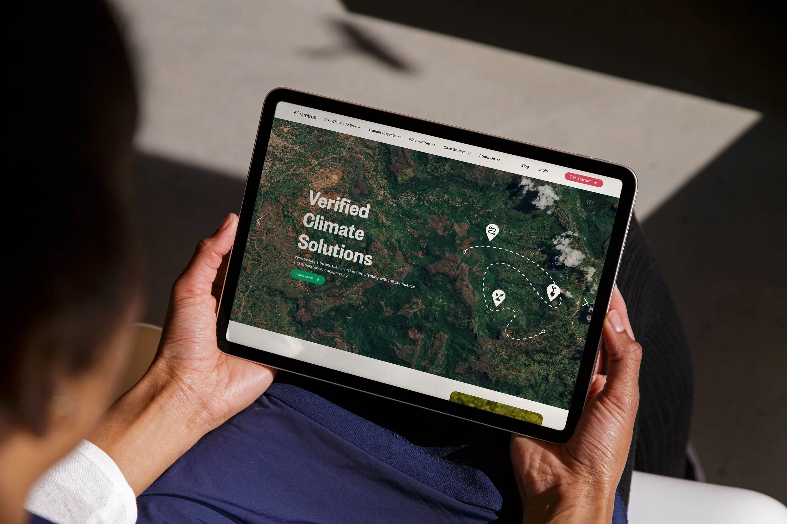 Tablet showing veritree’s website design by Laurelle Armet, with a green aerial landscape and “Verified Climate Solutions” headline, reflecting sustainability and innovative environmental design.