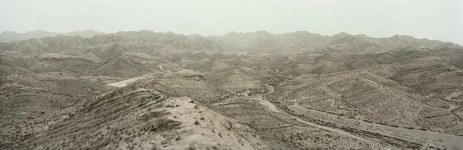 Desert. Bayin, Gansu, China, 2011. A man from an illegal mine walks on a dirt track leading out of the mountains. Desertification is a serious problem, consuming an area greater than that taken by farmland. Nearly all of China’s desertification occurs in the west of the country and approximately 30 percent of the country’s surface area is desert. China’s rapid industrialization, overgrazing, and the expansion of agricultural land accelerate the advance of deserts that are now swallowing up a million acres of grassland each year. 