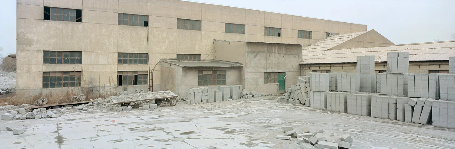 Brick Factory. Lanzhou, Gansu, China. 2011 A factory making concrete bricks is located on the outskirts of the city centre. Since 1949 Lanzhou has morphed from the capital of a poverty-stricken province into the heart of a major industrial area. The northern regions of China are poorly endowed with water and at the same time are rich in coal reserves. The 12th Five-Year Plan by the Chinese Government has set up most of the coal power bases in the north, north-west and north-east of the country. Heavy industry in this area has meant a high consumption of coal and water. Based on current figures, it is estimated that the 2015 development of the coal industry in the west will consume up to 10-billion cubic metres of water, approximately a quarter of the annual flow of the Yellow River. 