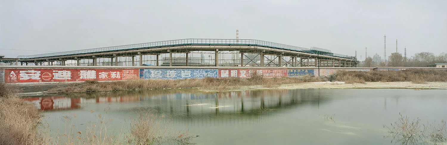 Industrial site. Lanzhou, Gansu, China, 2011. A polluted pond hidden from public view in an industrial district near the newly landscaped banks of the Yellow River. Factories disposing waste illegally often pipe effluent deep underground or late at night to avoid being caught. Illegal dumping of chemical waste has become a widespread problem. About one third of the industrial wastewater and more than 90 percent of household sewage in China is released untreated into rivers and lakes. As China continues to prosper, the public—fueled by a sense of individual rights related to increasing openness and prosperity—have shown an increased concern for the environment, which has led to more public disputes. In 2006, the government received 600,000 environment-related complaints, a figure that has risen roughly 30 percent each year since 2002. 