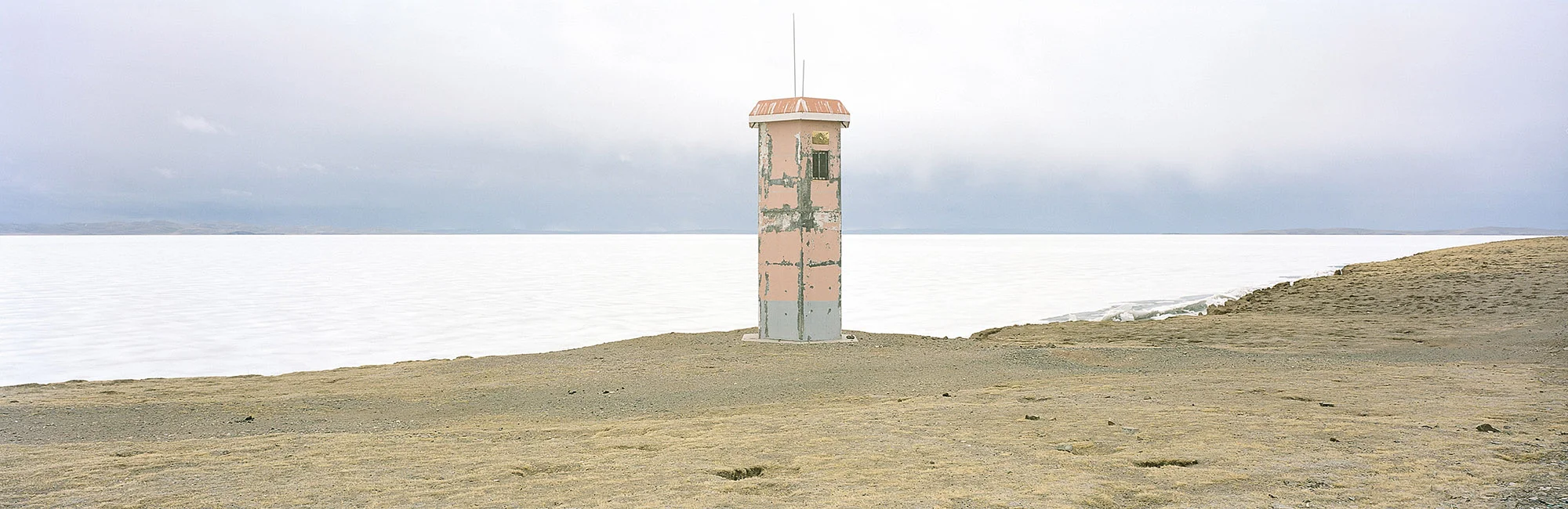 Viewing Outpost. Sanjiangyuan National Nature Reserve, Qinghai, China. 2014 A viewing tower on the frozen banks of Ngoring Lake rises above China’s highest wetlands ecosystem, located in the Sanjiangyuan National Nature Reserve. The lakes, glaciers, and vast underground springs of the Tibetan plateau—often called China’s “water tower”—supply nearly 50 percent of the Yellow River's volume. But the warmer climate is sending the delicate ecosystem into shock. According to the Chinese weather bureau, temperatures in the region may rise by as much as five degrees Celsius by the end of the century. Melting ice may add water to the river in the short term, but in the long-term the various manifestations of climate change could result in more dry spells. In recent years, the waters of Ngoring Lake, the largest lake in the region, have risen to levels higher than their historical average. The lake’s growth may be due to the melting of permafrost, which in the short term can lead to more surface water, but in the long term could accelerate desertification and cause the release of enormous quantities of methane gas.