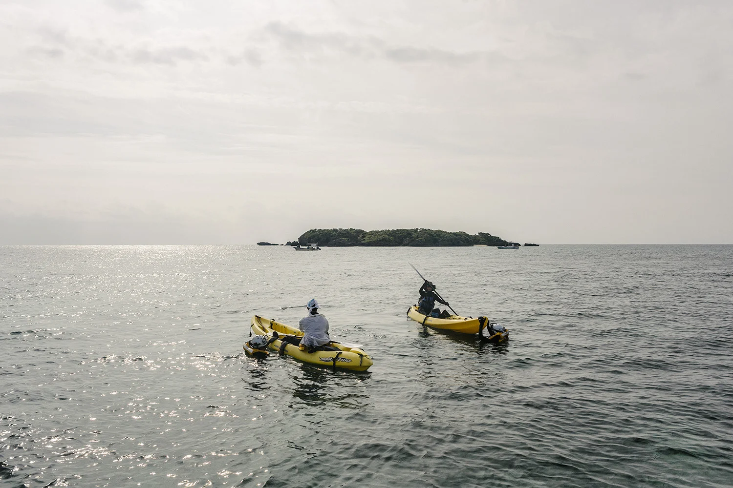 Protestors in kayaks are restrained by Japanese coast guards swimming in the sea. Technically by law, non-motorised boats are outside the jurisdiction of the Japan Coast Guard, an important reason for protestors to use kayaks. Henoko, Okinawa, Japan.