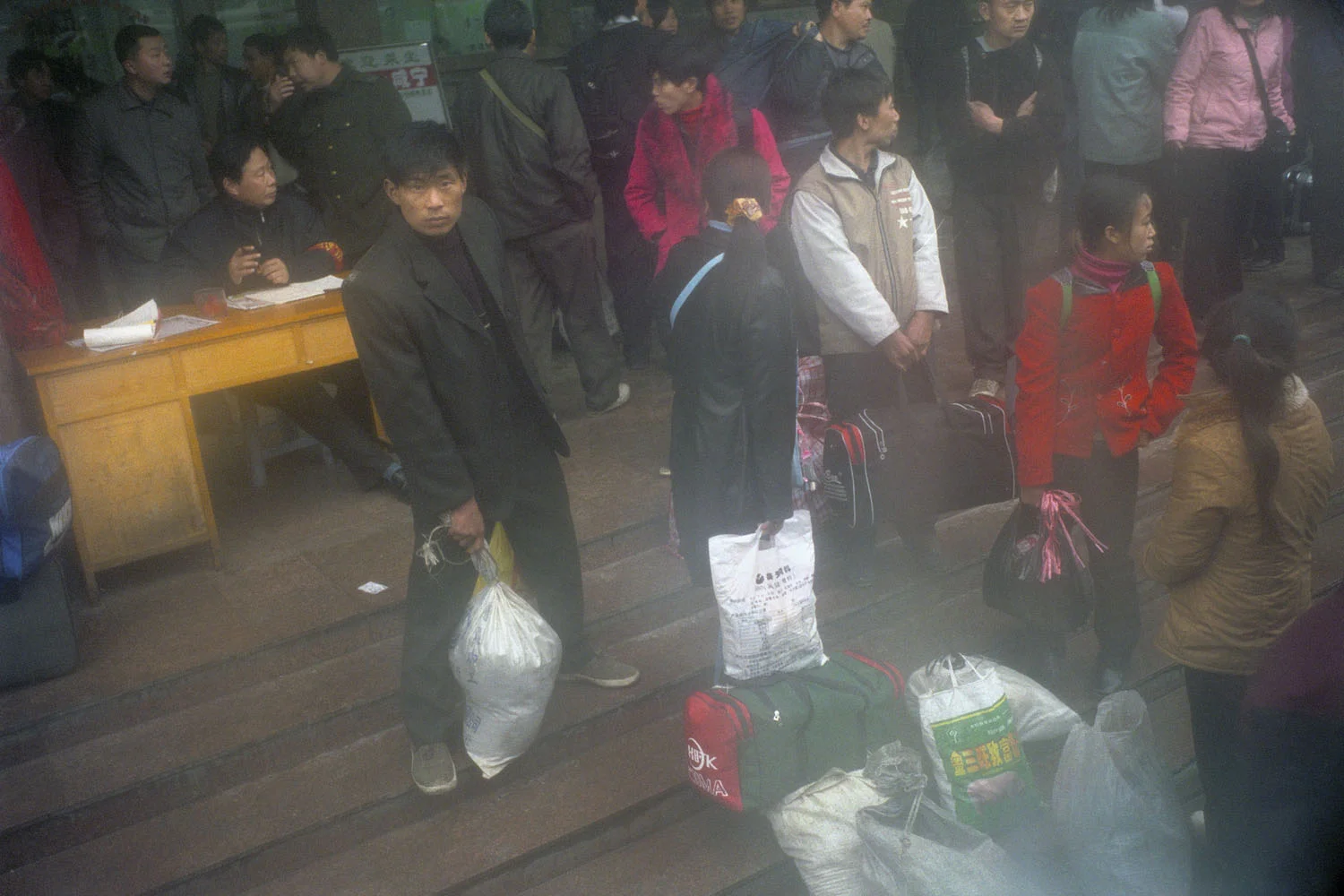 Migrant worker and travellers. Boat services to Yichang are disrupted due to the construction of the dam and the last section of this journey are replaced by bus services. Yichang, China.