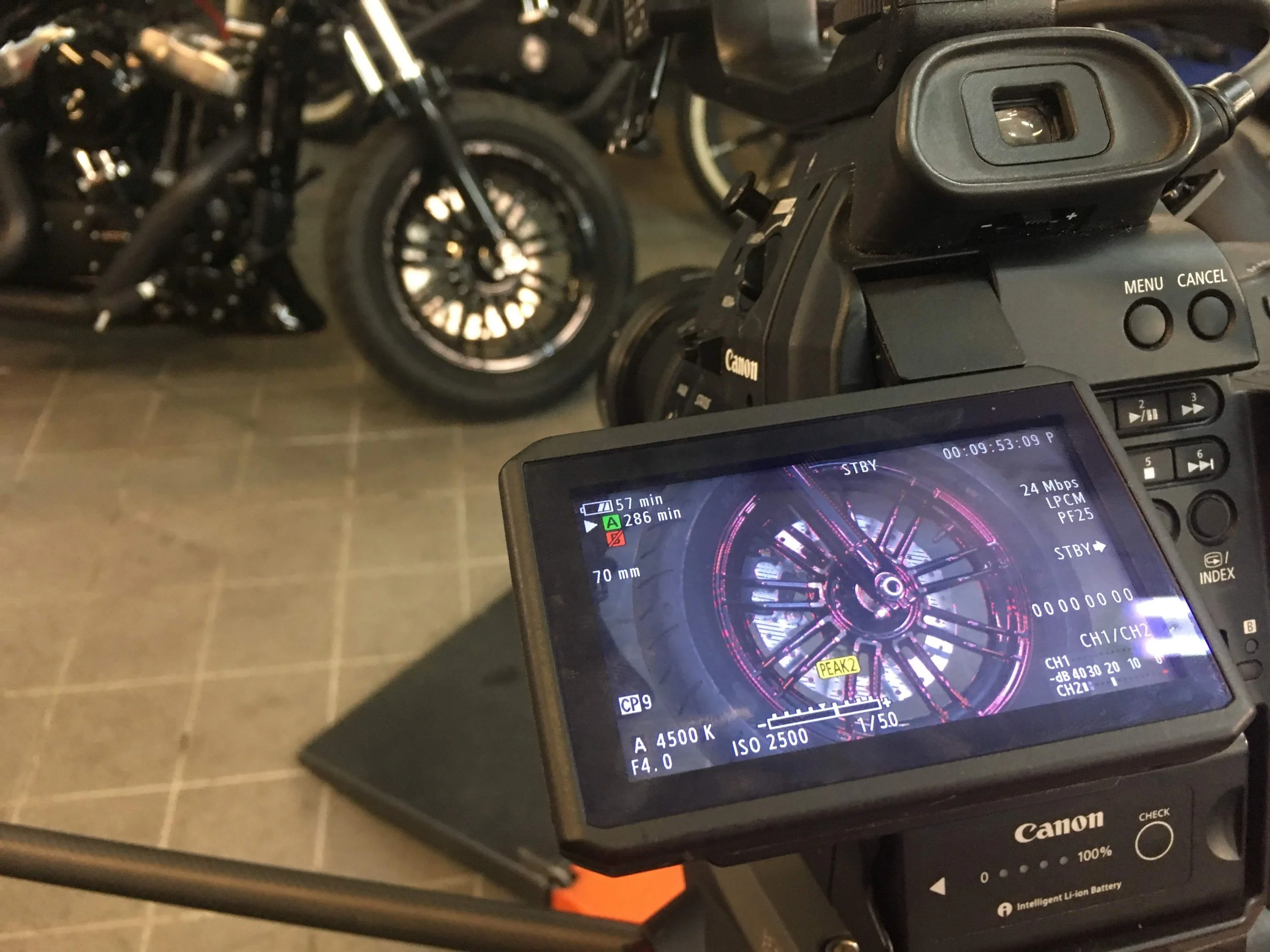 Professional video camera pointing at motorcycle wheel
