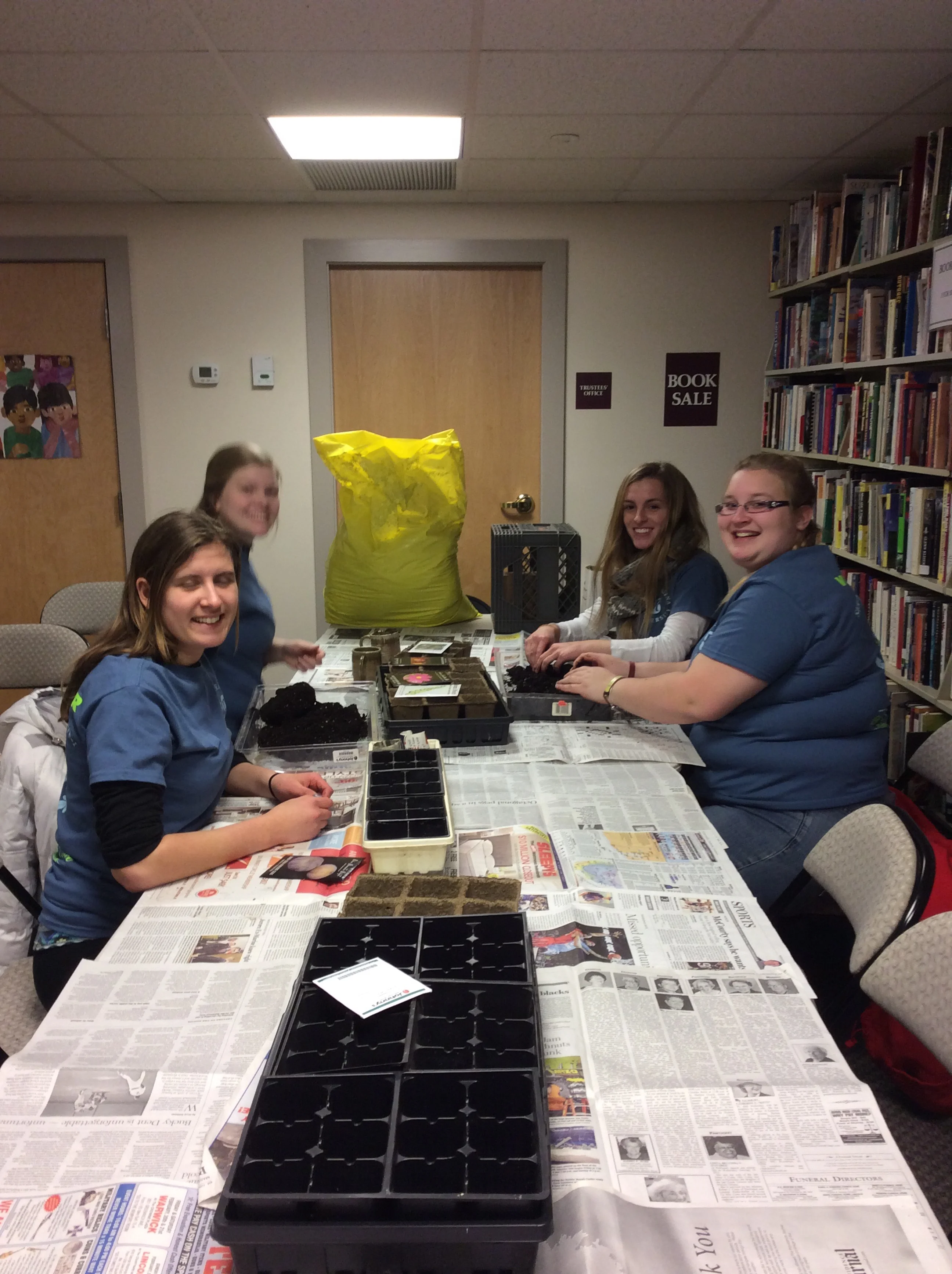 Four of the fourteen students who helped shovel ice from the parking lot, tutored in the use of electronic devises and digital media, shelved books, and started seeds.