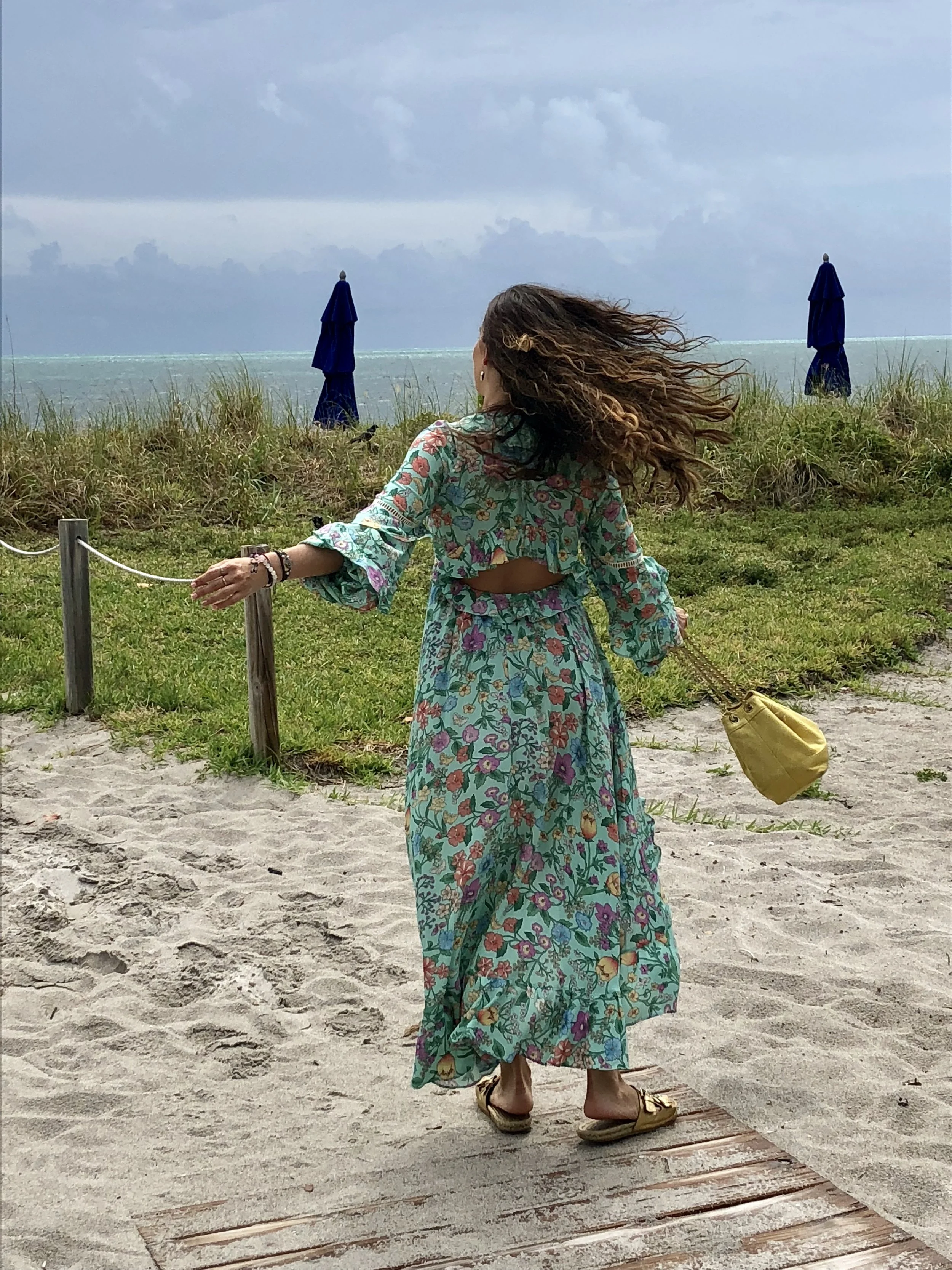 In my Sayulita frill gown from Spell Designs , Aldo gold sandals and Chanel vintage bucket bag at the beach in Miami.