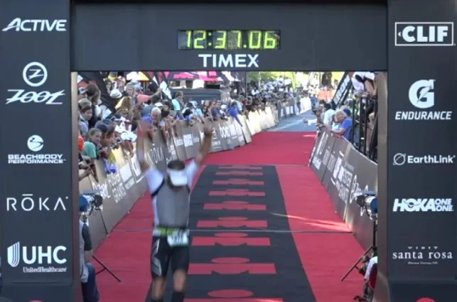 A Good Wolf athlete triumphantly crossing the finish at his first Ironman.