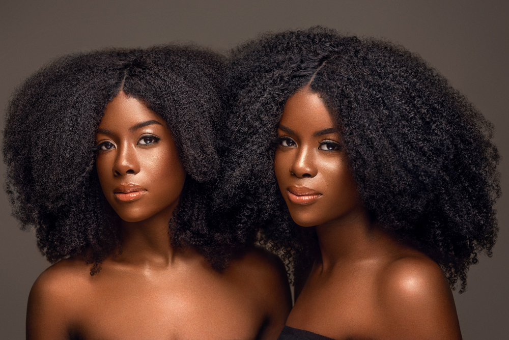  A portrait of African American twins with natural hair textures shot in studio. 