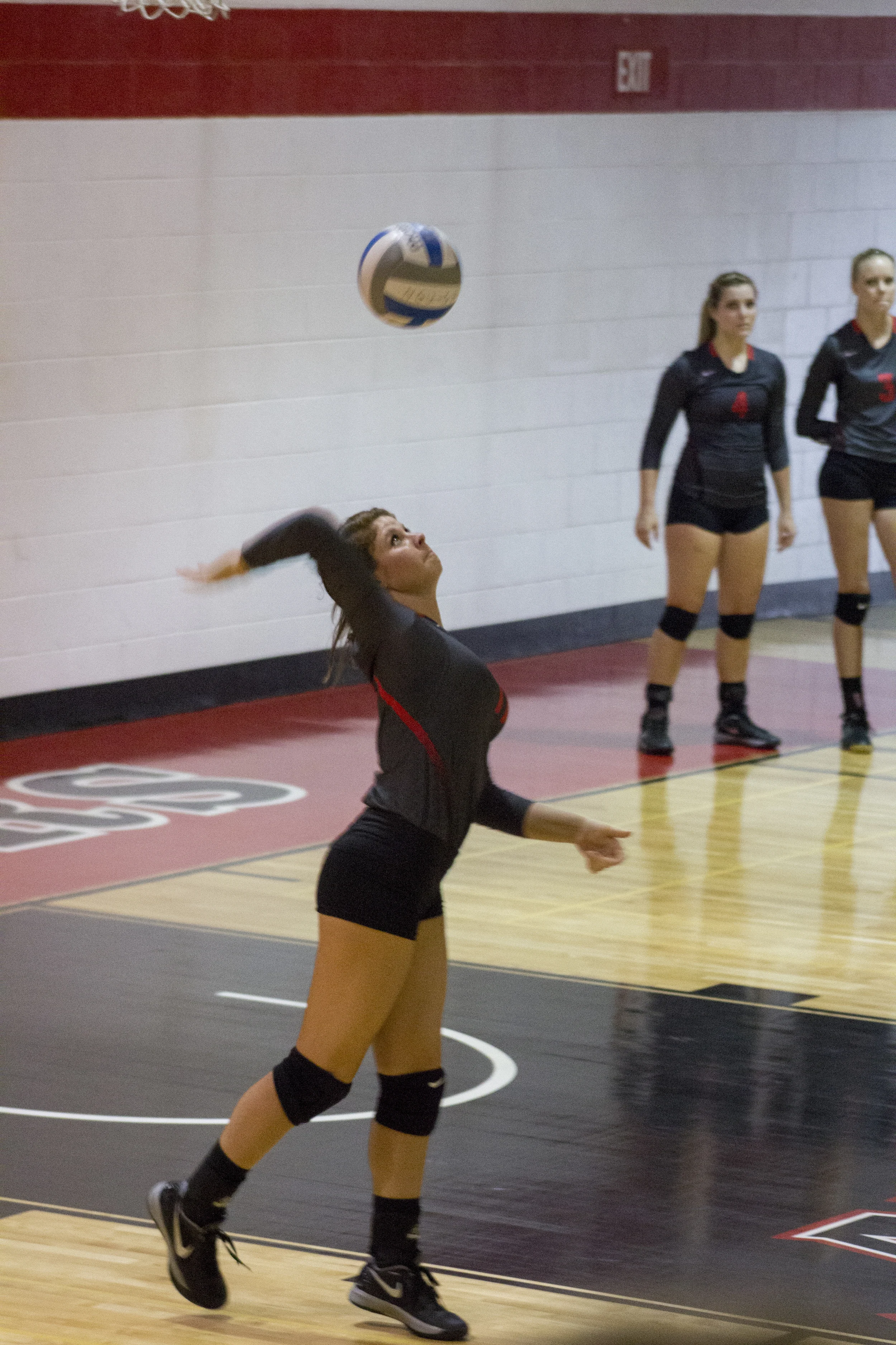 Junior Jenna Farrato serves to start the match.