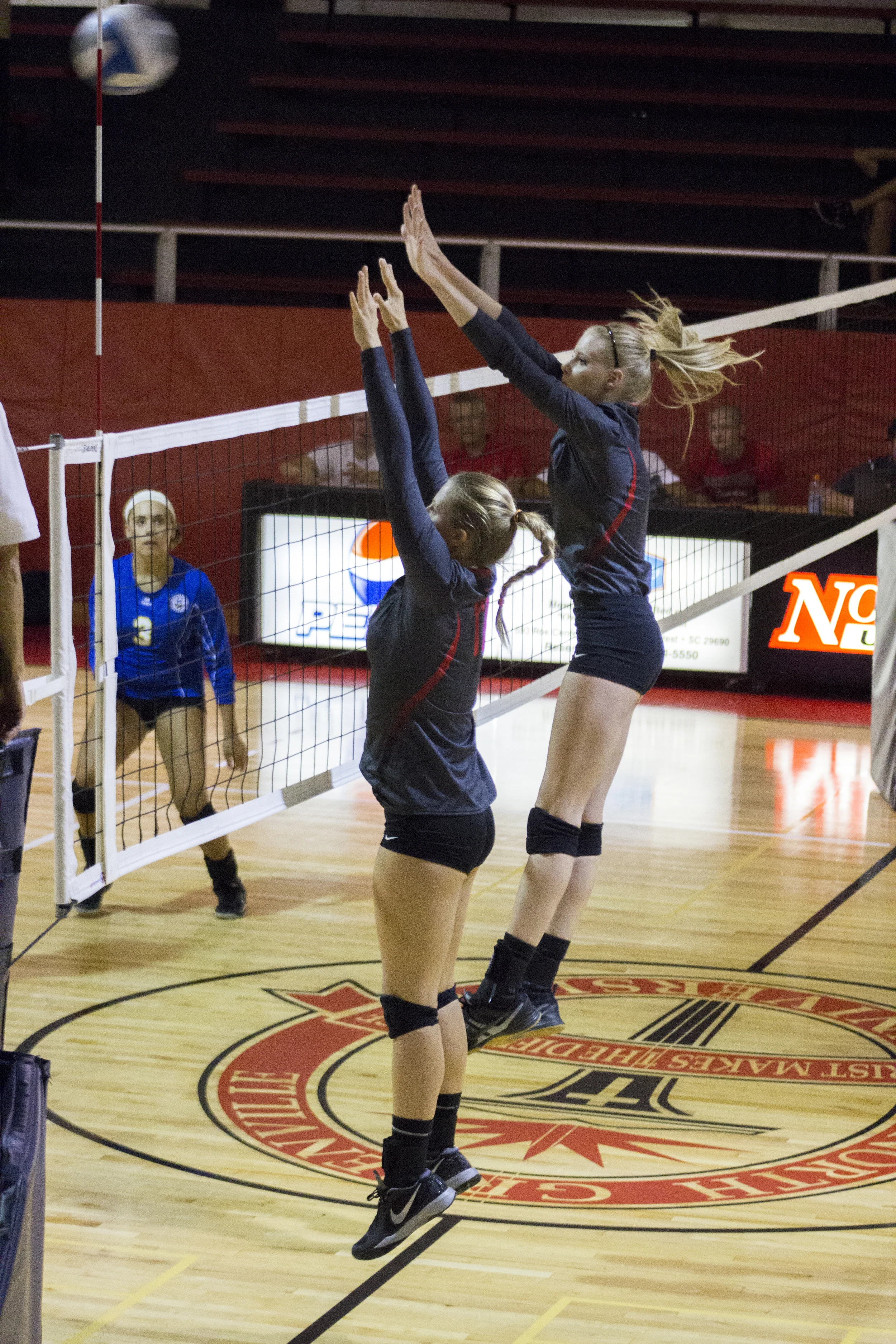 Sophomores Rachel Burts and Hannah Helbert attempt to block a return. 