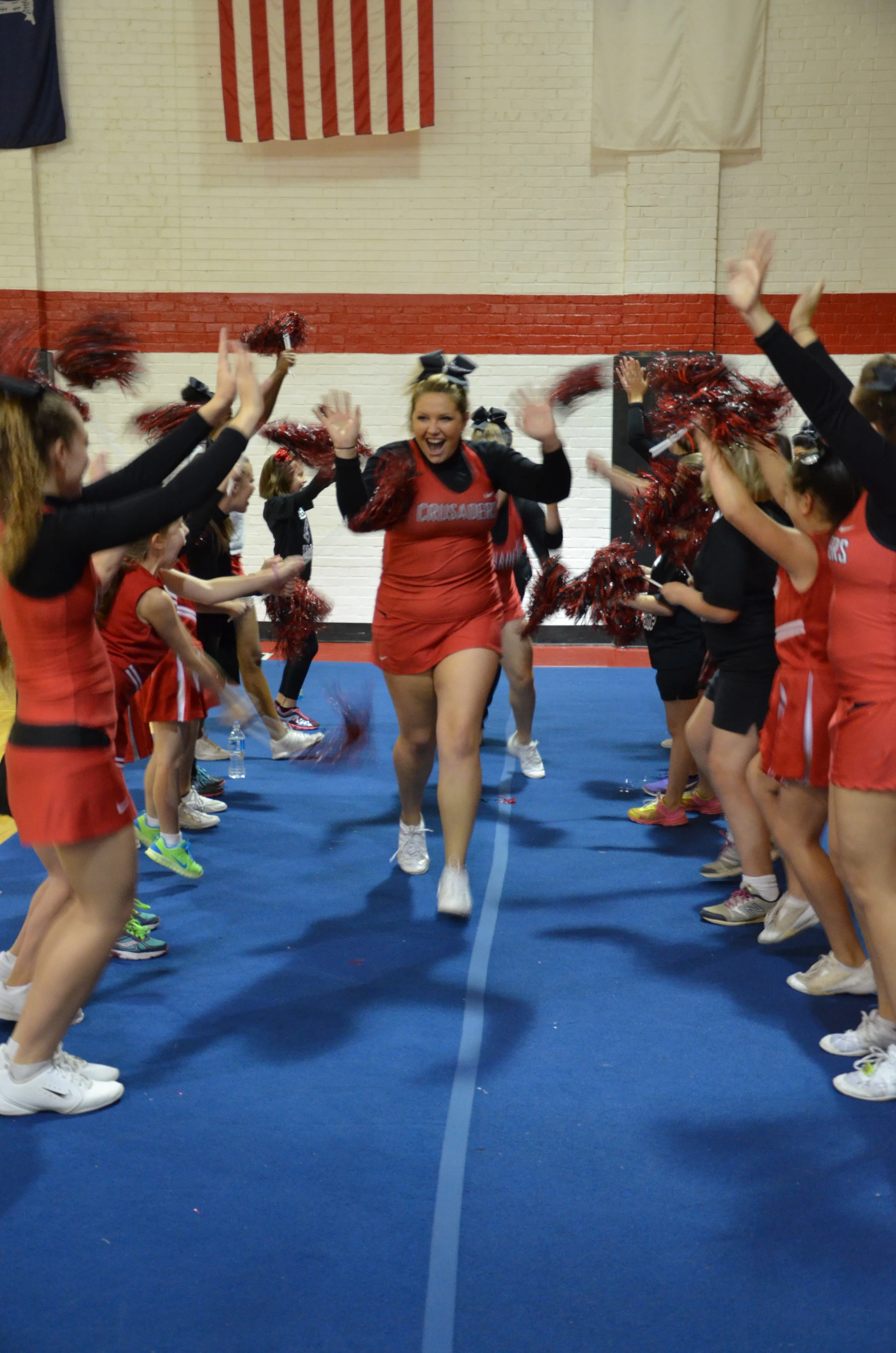 Mini-Crusaders cheer on the NGU Cheerleaders as they run through the tunnel.