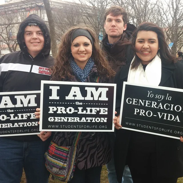 Aivarenga joins fellow NGU students in holding up her pro-life poster for the march against abortion. 