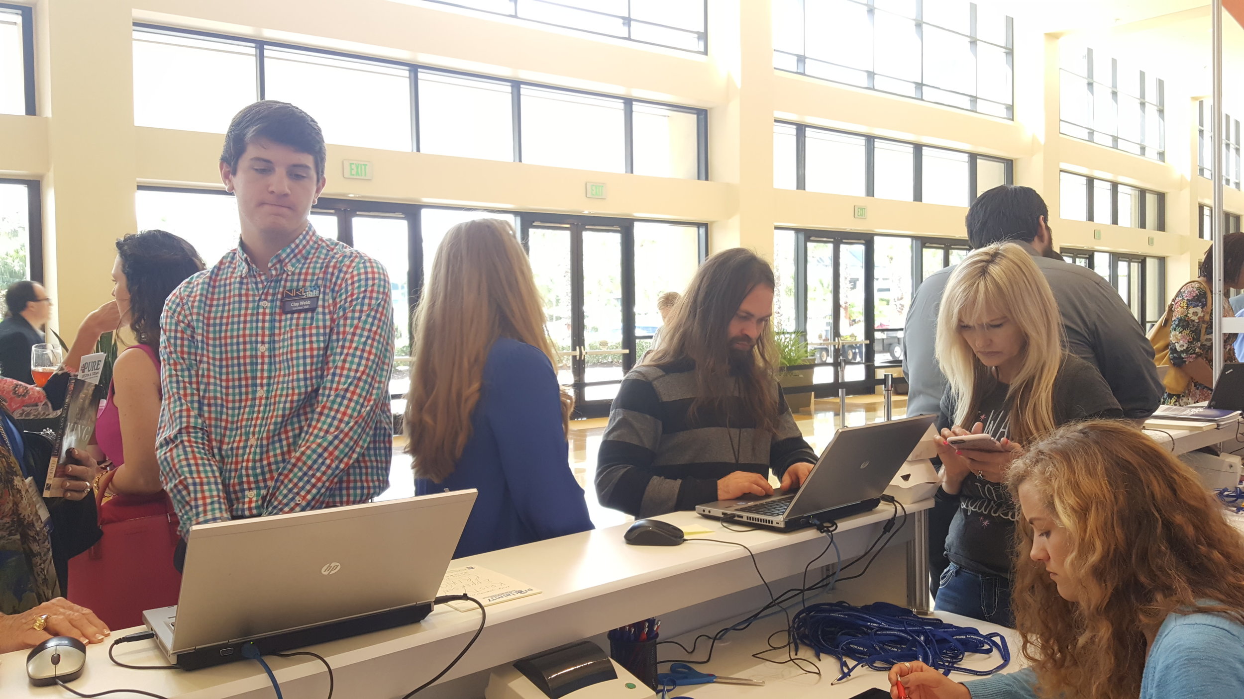 Clay Webb and Harley Watkins help guests sign in as fellow writer Hunter Merck comes in for the second shift.