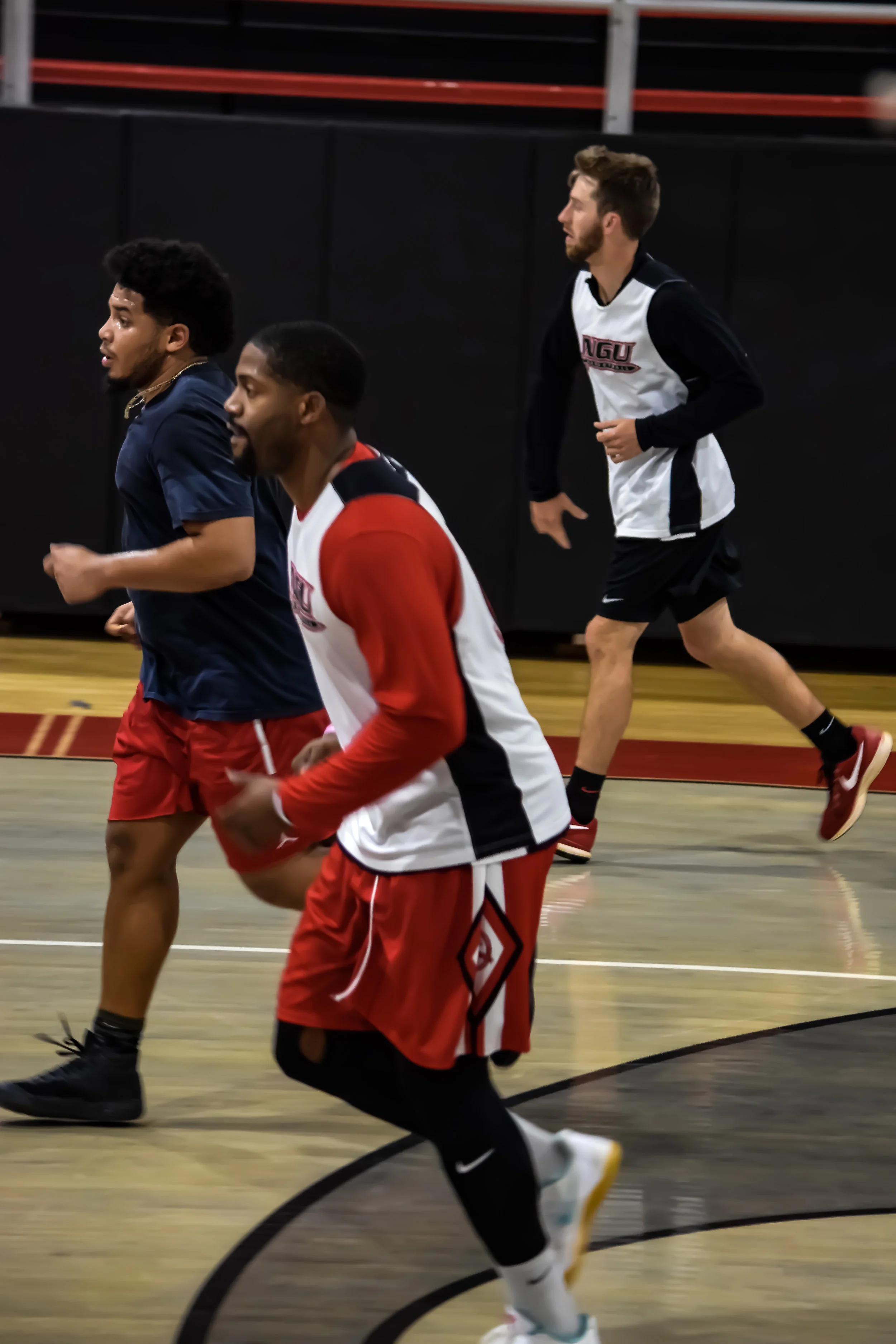 Jamaal Pryor, Bennette Hill, and Daniel Glaidous run down the court. 