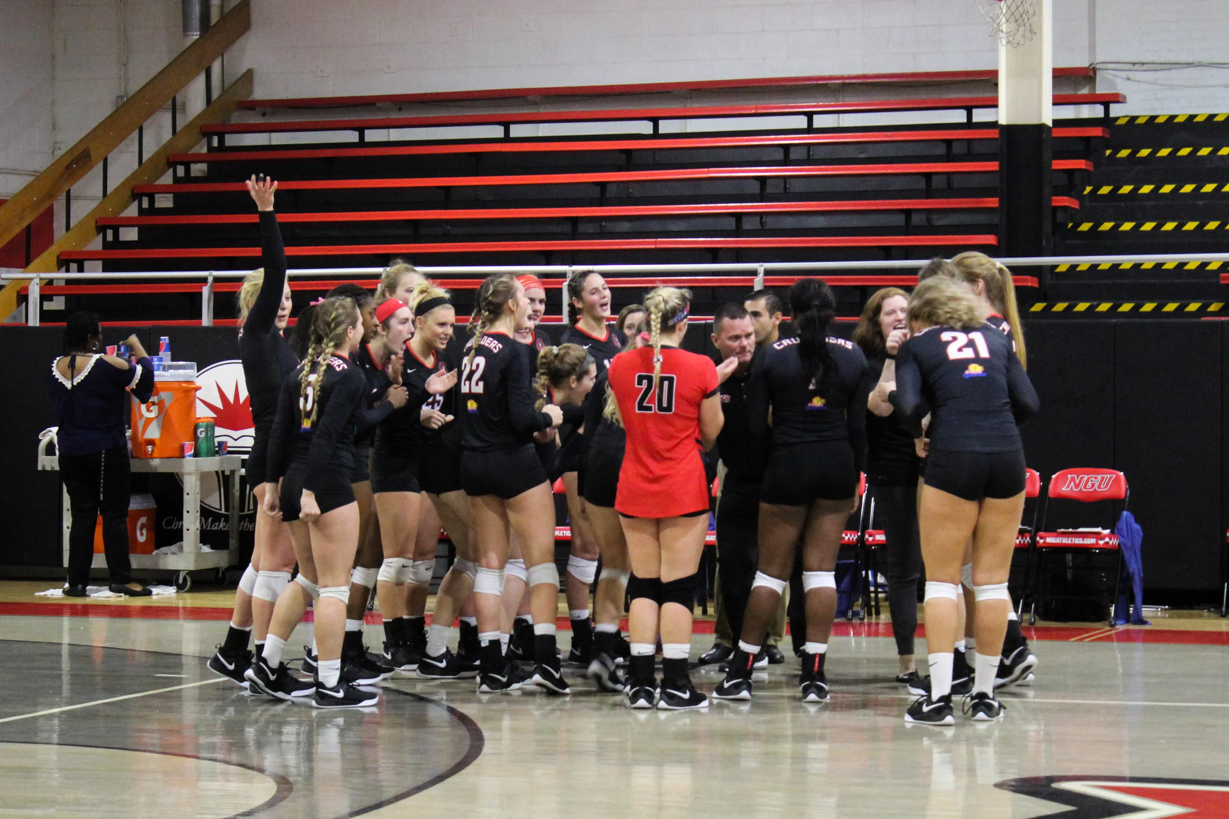After winning a set, the NGU women’s volleyball team huddle together to cheer on the players that were on the court.