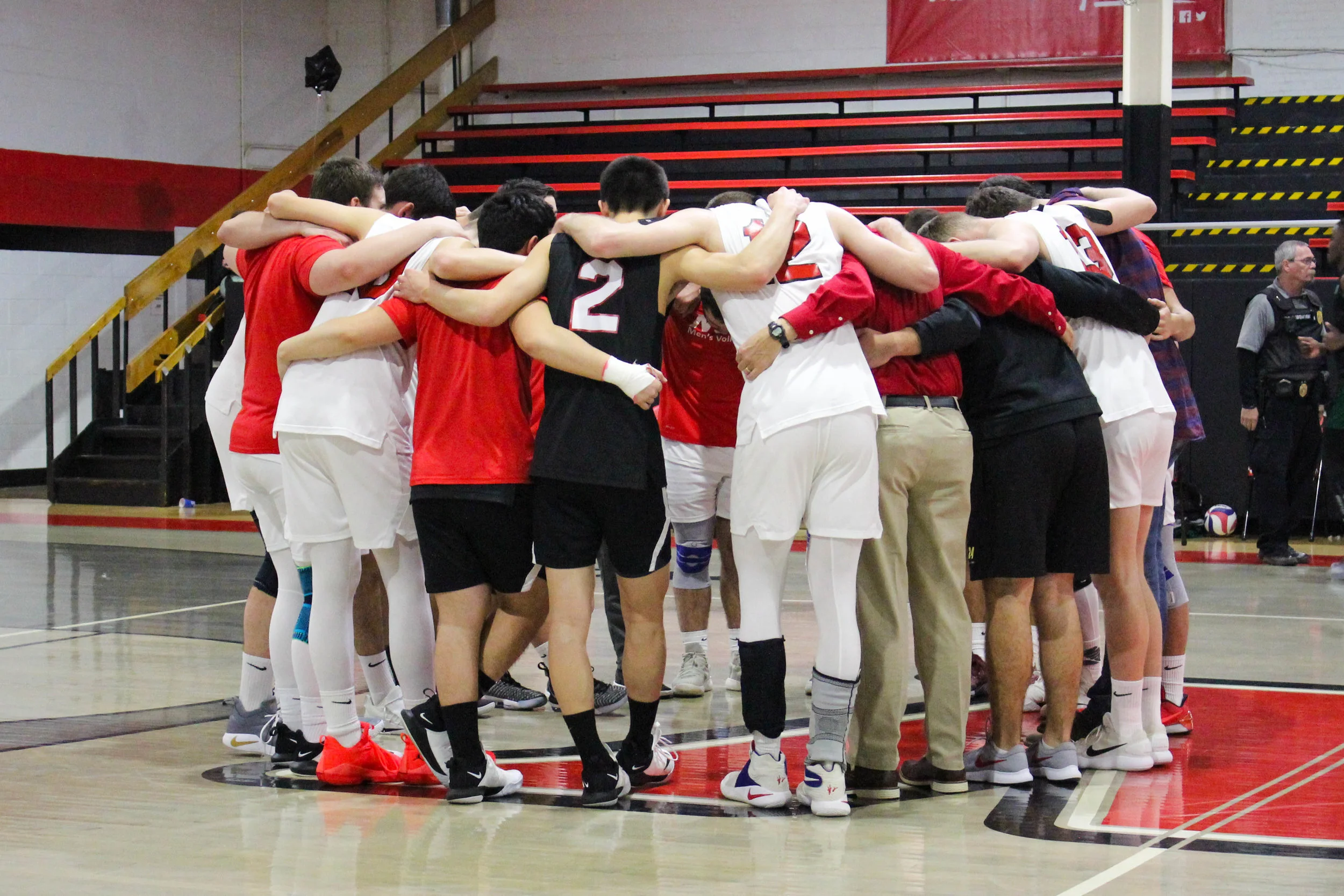 The Crusader men’s volleyball team huddle together to pray after the game.