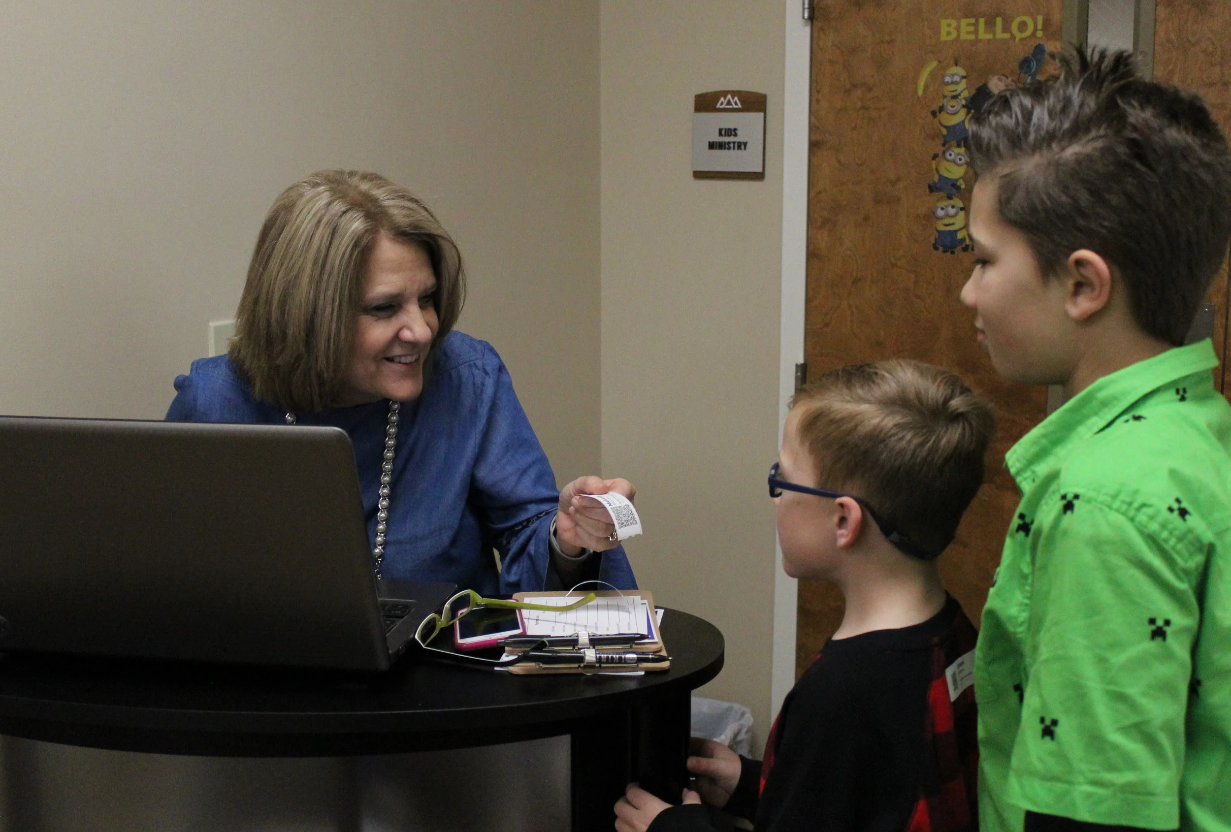 On Sunday mornings, children from ages one to 12 are electronically checked in specifically into their class according to age. Here, LeeAnn Streetman, the children’s pastor’s wife, welcomes our youth Jaxson McManus and Brian Fowler.