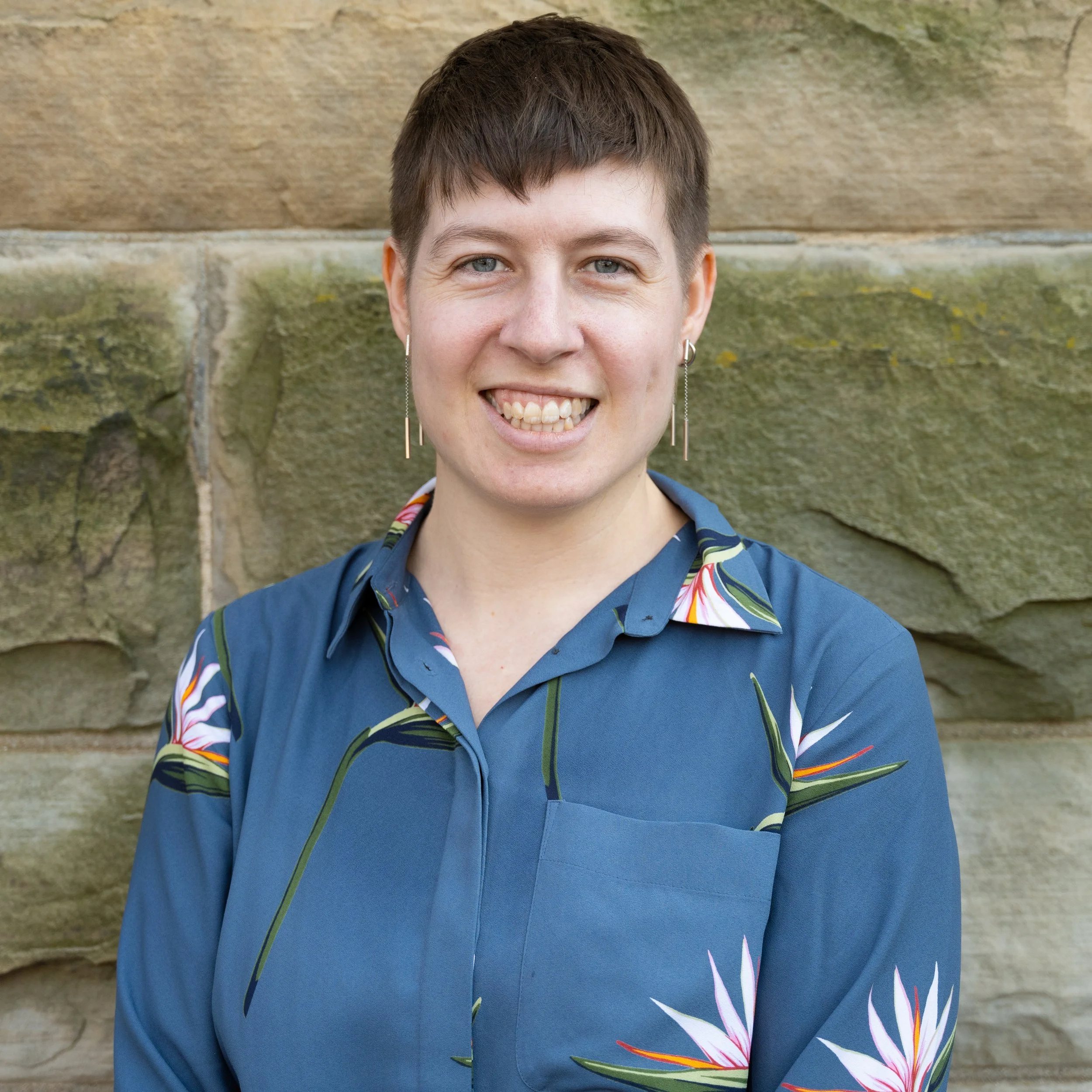 Headshot photograph of white woman with blue shirt