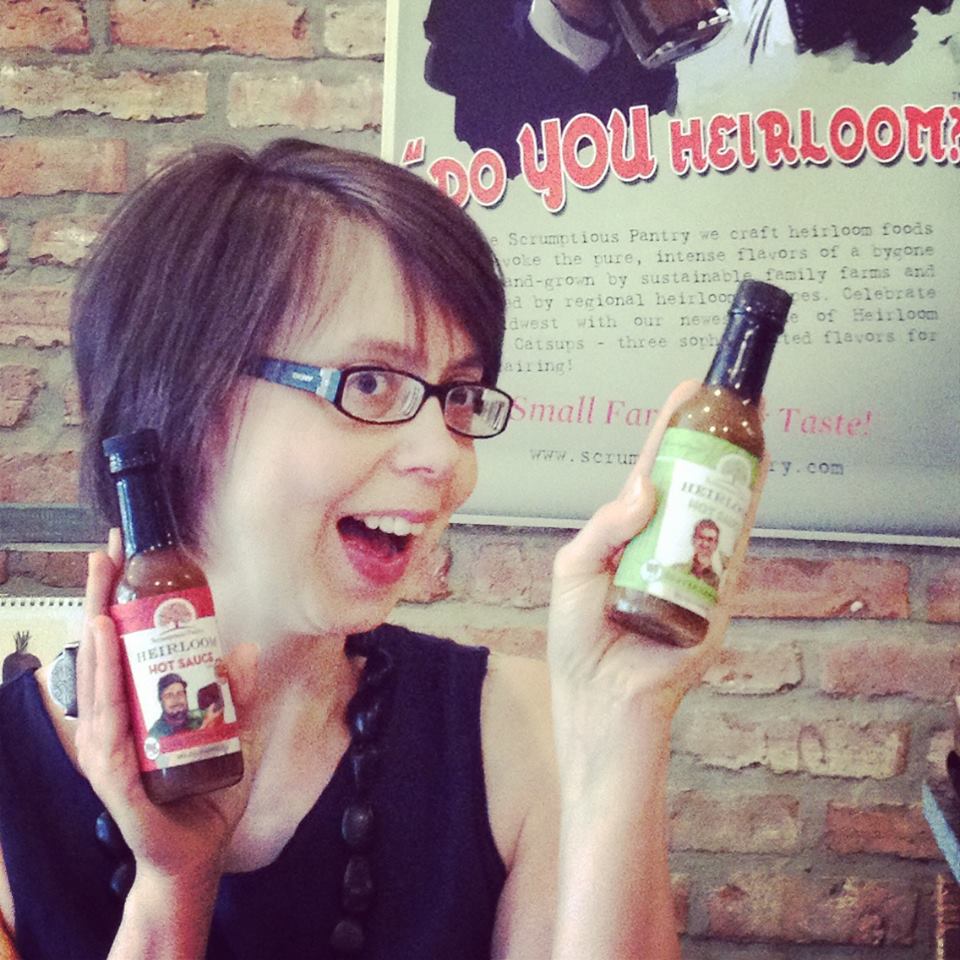 Smiling Woman Holding 2 Bottles of Hot Sauce - Five Points Holistic Health