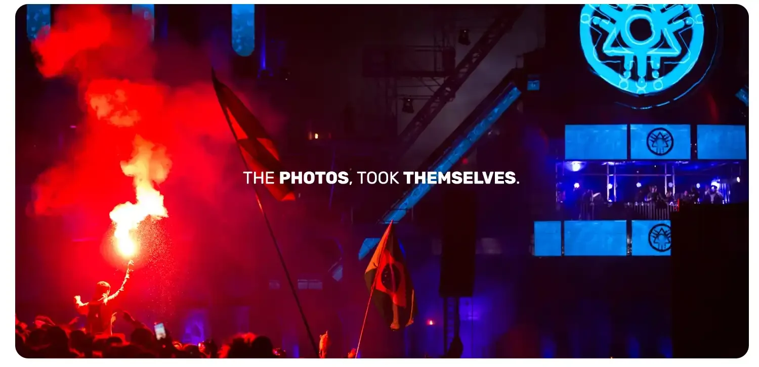 Photograph of a man holding a red flare in the crowd of boomtown festival