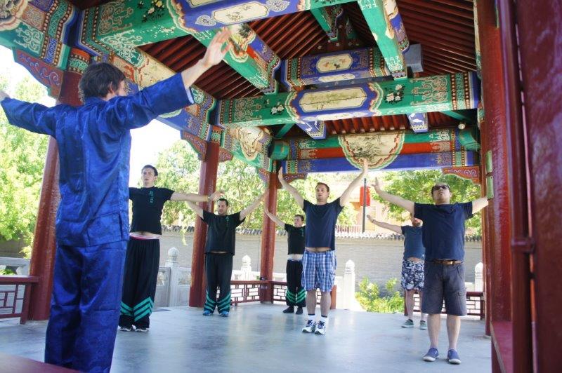 Students practicing Lifting the Sky, under the pavilion in the beautiful and tranquil Happy Garden at the Museum