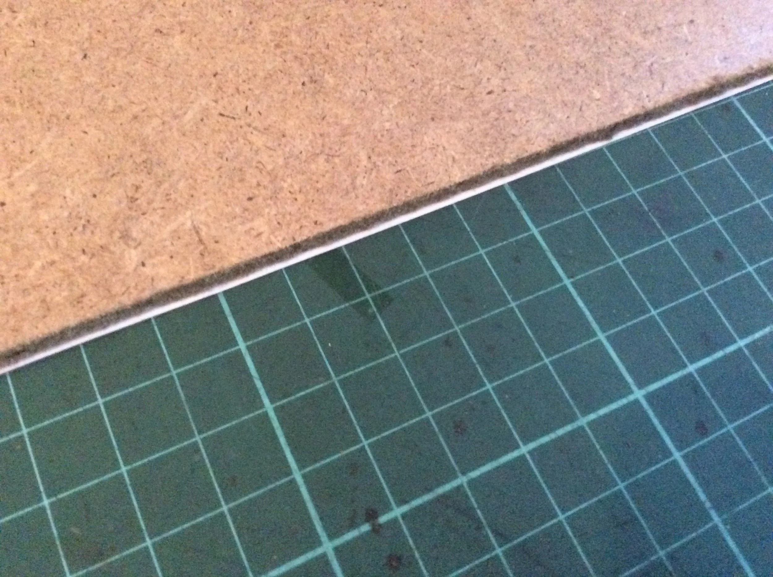 It is better for it to hang over slightly to make sure the edge of the board does not touches the canvas or stretcher bars.