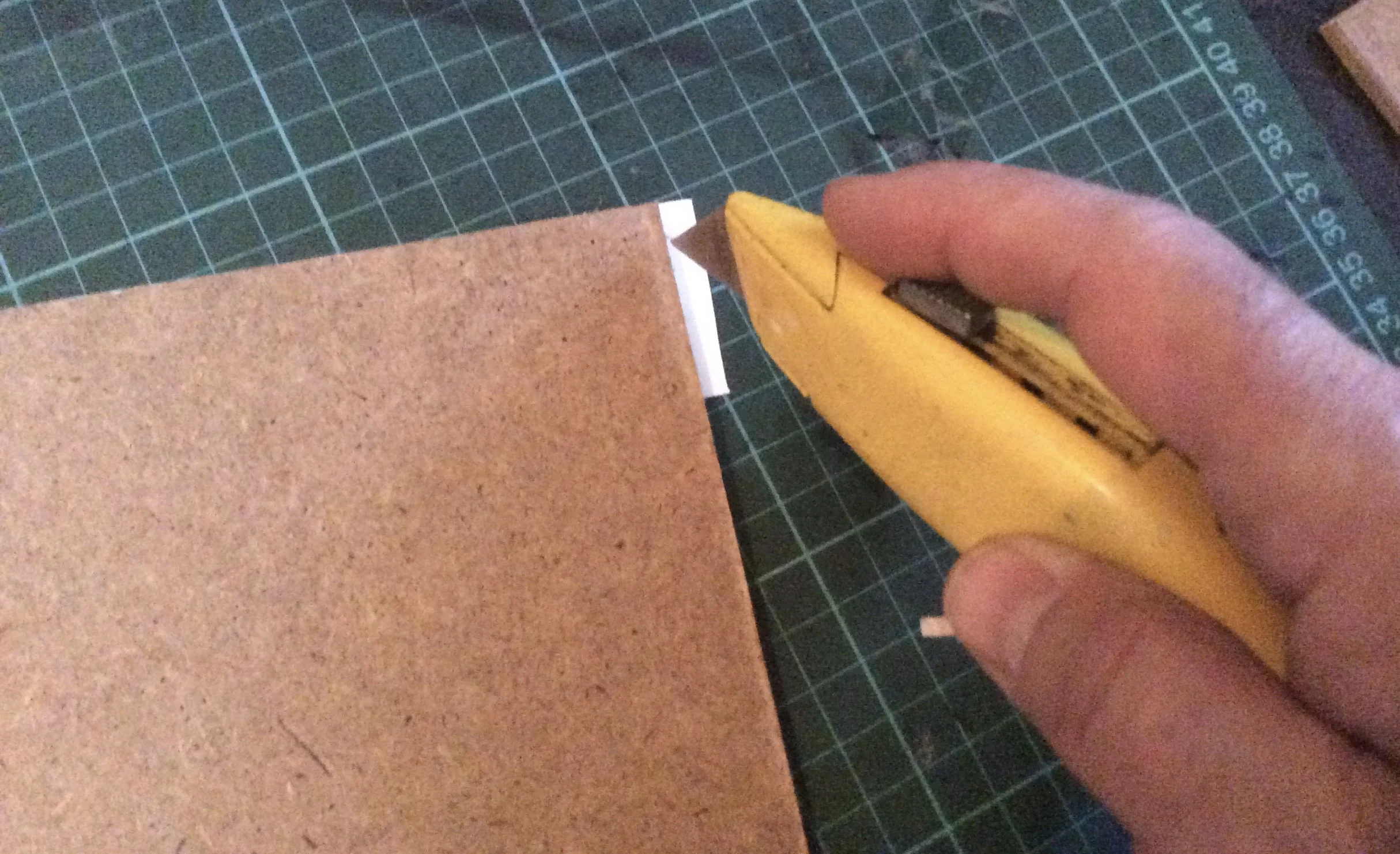 Adding the strips to the reverse of the board is better than sticking it directly to the canvas and stretcher bars, because you can easily flip the board over, and neatly trim the strips back a little if it hangs over too much.