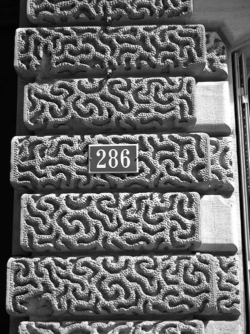 Detail of an image by Tangopaso, 2015. Detail of the Building 286 boulevard Saint-Germain, Paris 7th arrond. (France). Public domain, via Wikimedia Commons.