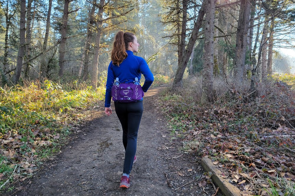 A woman wearing the Osprey Tempest fanny pack on a day hike