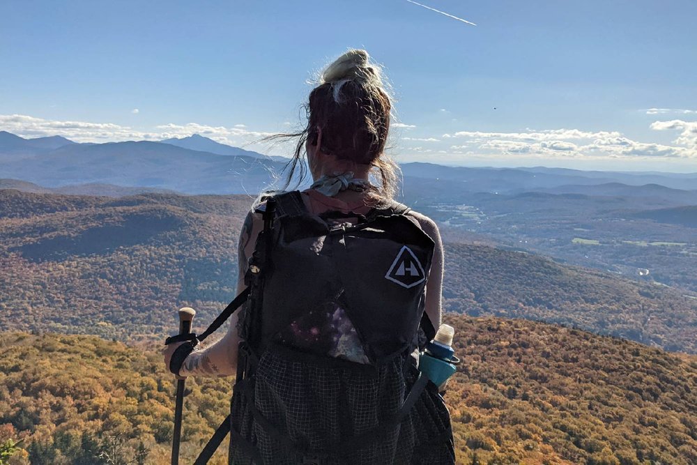 A hiker wearing the Hyperlite Mountain Gear Southwest 2400 looking at a distant mountain view